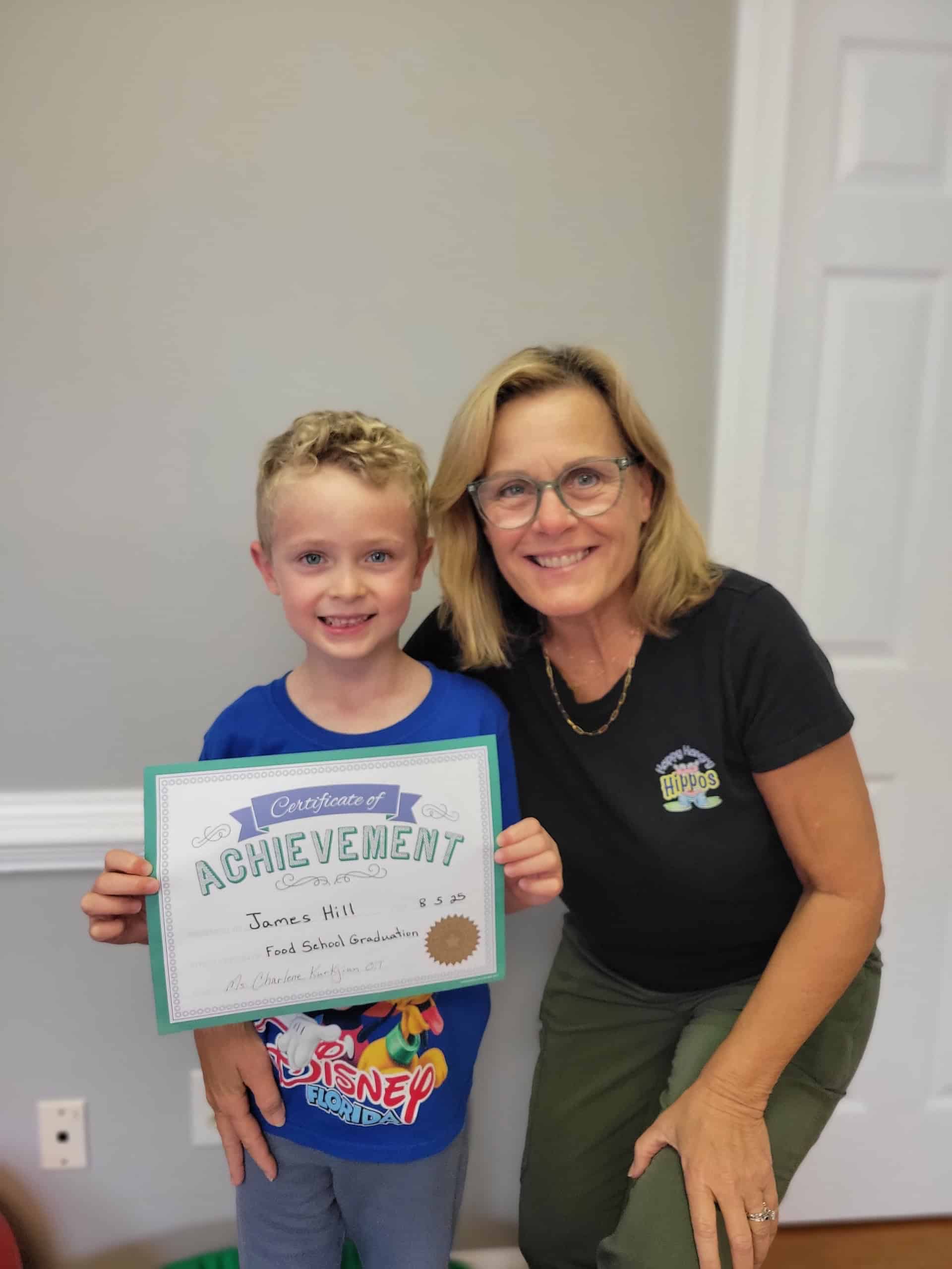 Child holding achievement certificate proudly.
